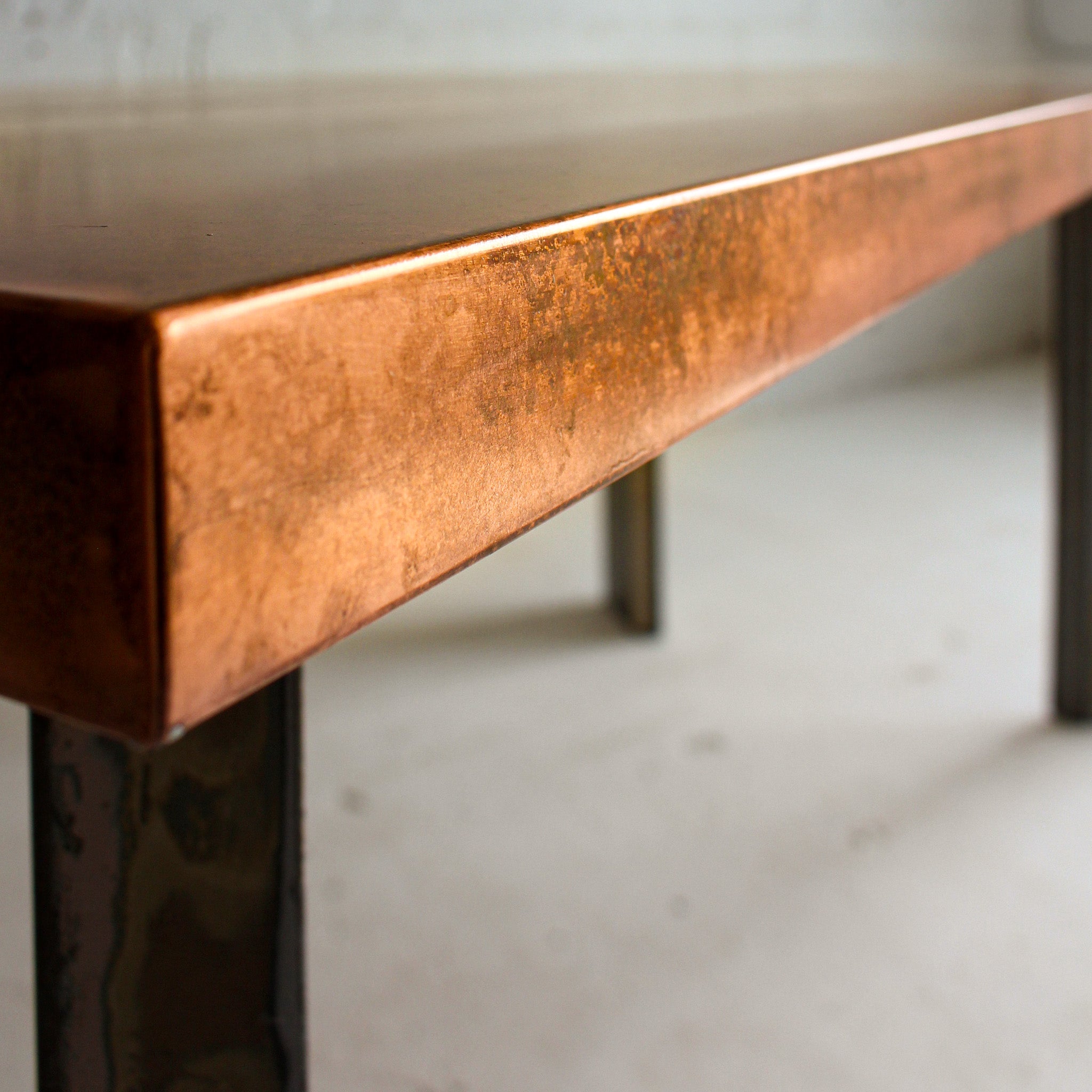 Book tower dining table close up view reclaimed materials copper top