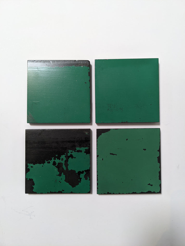 4 Schoolhouse Chalkboard Coasters in distressed green and slate. Top down view.