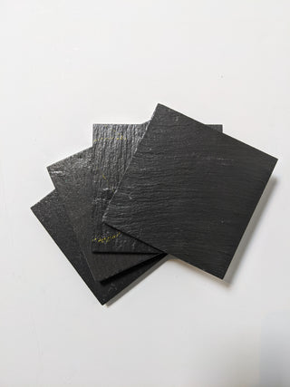 4 Schoolhouse Chalkboard Coasters in dark slate. Stacked view.