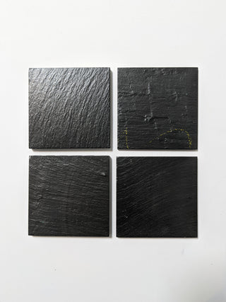 4 Schoolhouse Chalkboard Coasters in dark slate. Top down view.